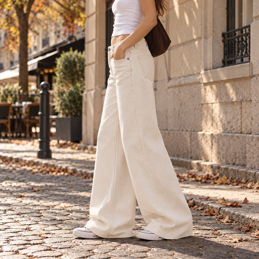 Vue de profil d'un pantalon large blanc à jambes fluides sur pavés
