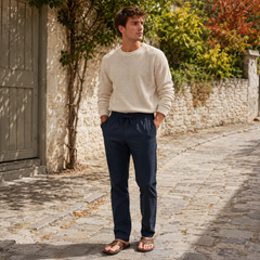 Pantalon homme bleu marine à cordon noué, porté avec un pull écru en maille