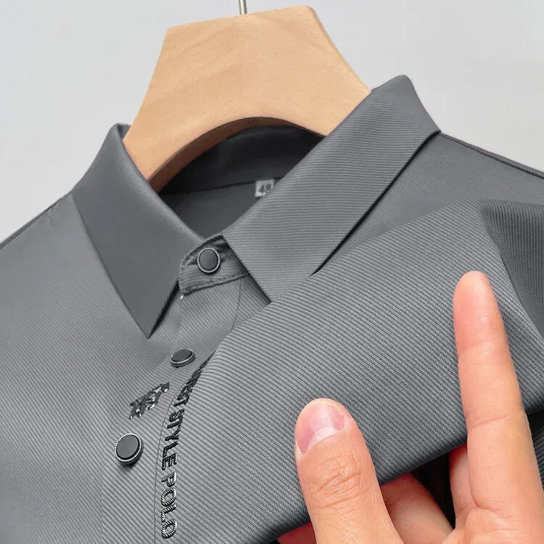 Gros plan sur la broderie logo et les boutons du polo gris anthracite