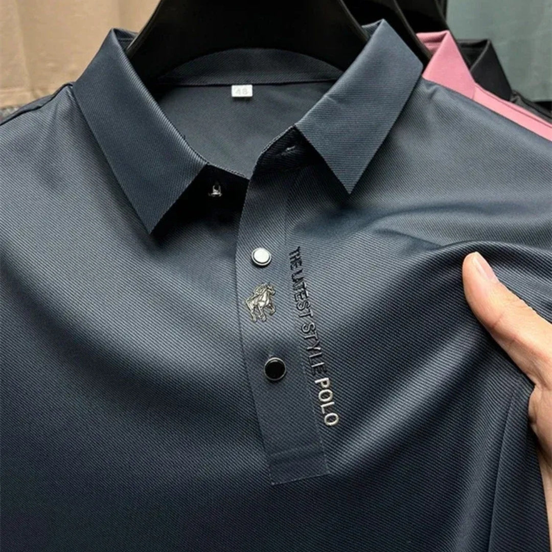 Gros plan sur le col boutonné bleu marine avec inscription brodée et logo métallique