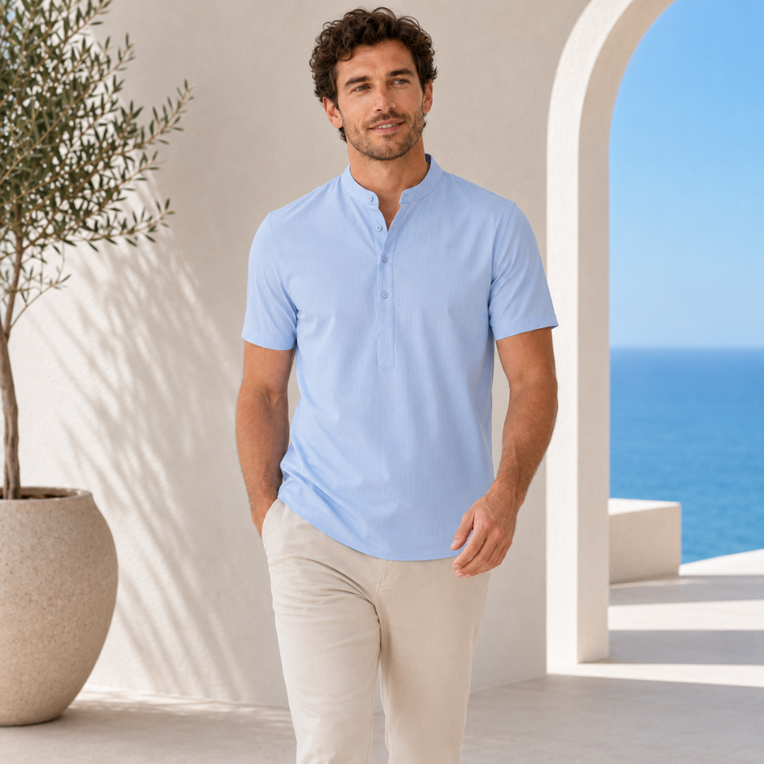 Homme portant un polo col mao bleu clair face à la mer