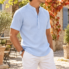 Polo col mao bleu clair porté de trois quarts avec pantalon blanc