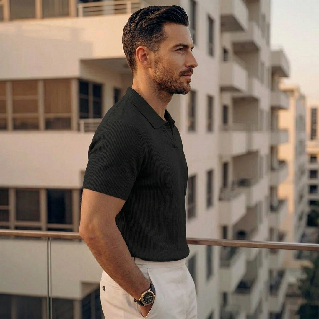 Homme en polo noir ajusté à maille côtelée, main dans la poche