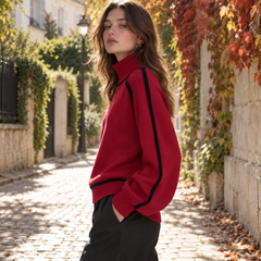 Vue de profil du pull rouge à col roulé, liseré noir le long de la manche
