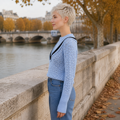 Vue de profil du pull bleu ajouré, manche longue et poignet large côtelé