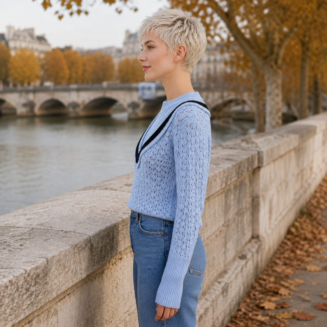 Vue de profil du pull bleu ajouré, manche longue et poignet large côtelé
