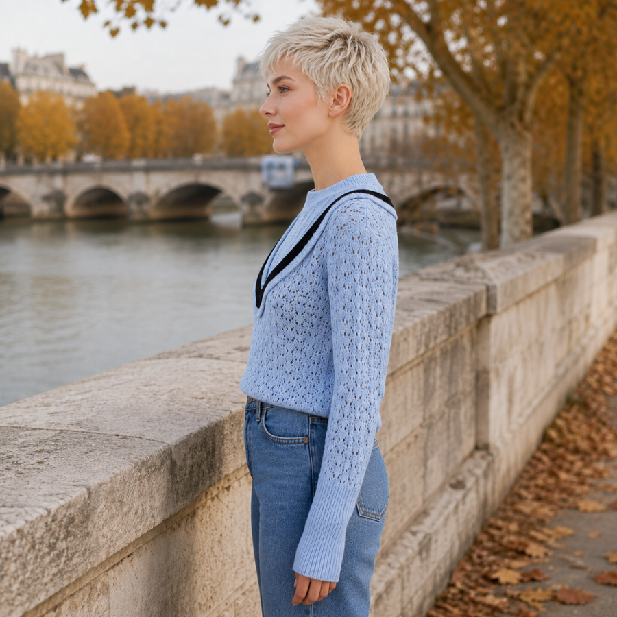 Vue de profil du pull bleu ajouré, manche longue et poignet large côtelé