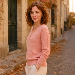 Vue de profil du pull rose ajouré, manches longues et poignets côtelés