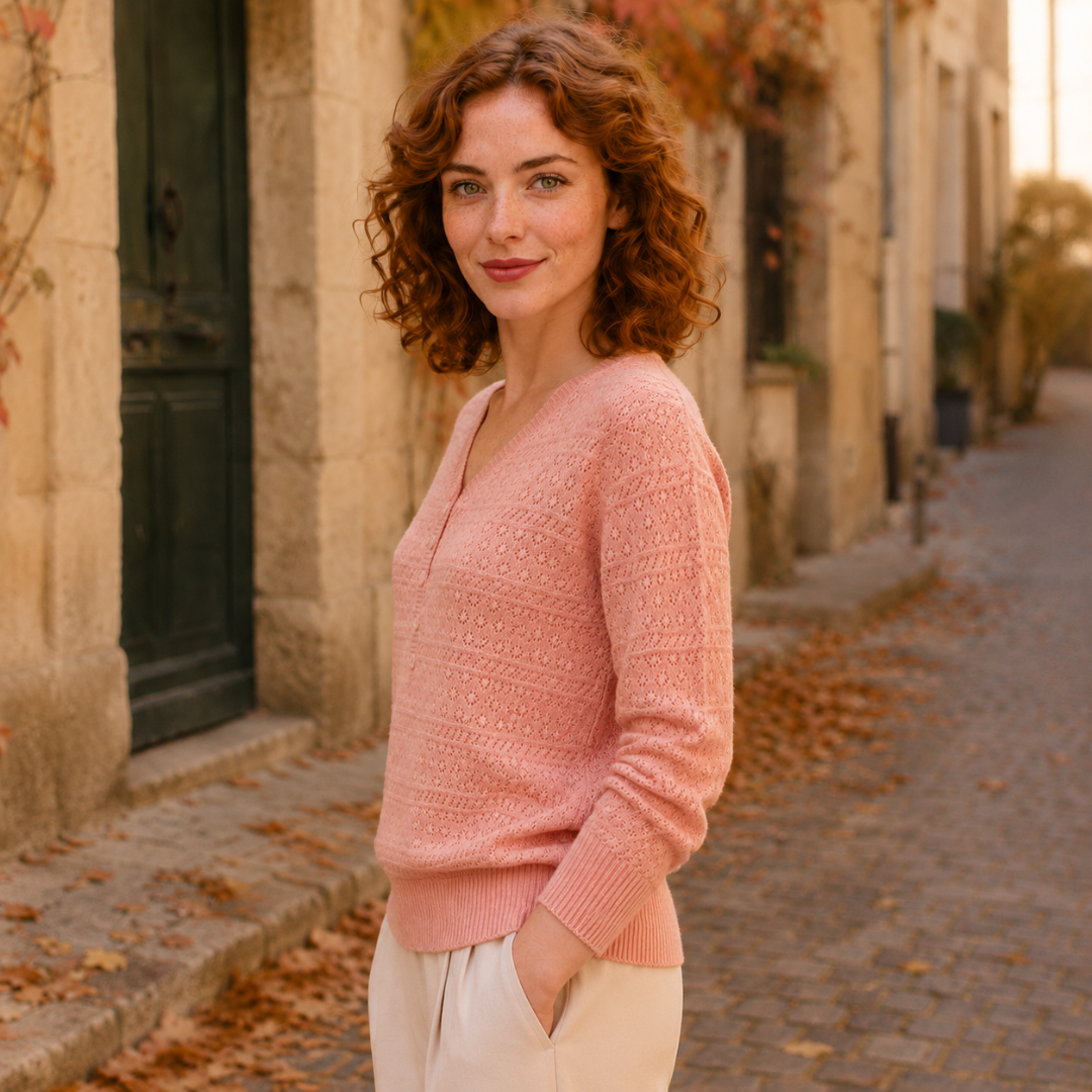 Vue de profil du pull rose ajouré, manches longues et poignets côtelés