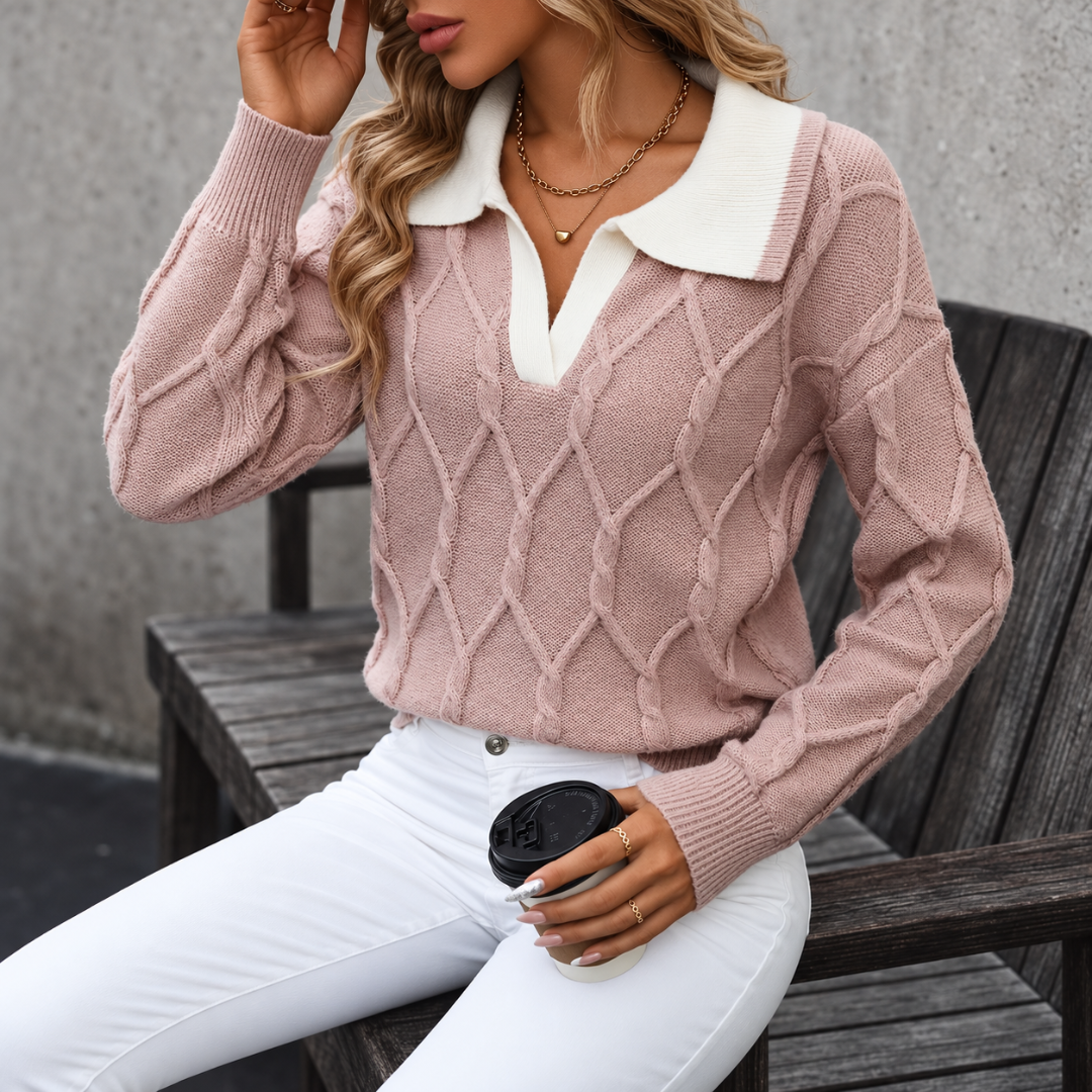 Femme assise portant le pull rose, col chemise contrastant et poignets côtelés visibles