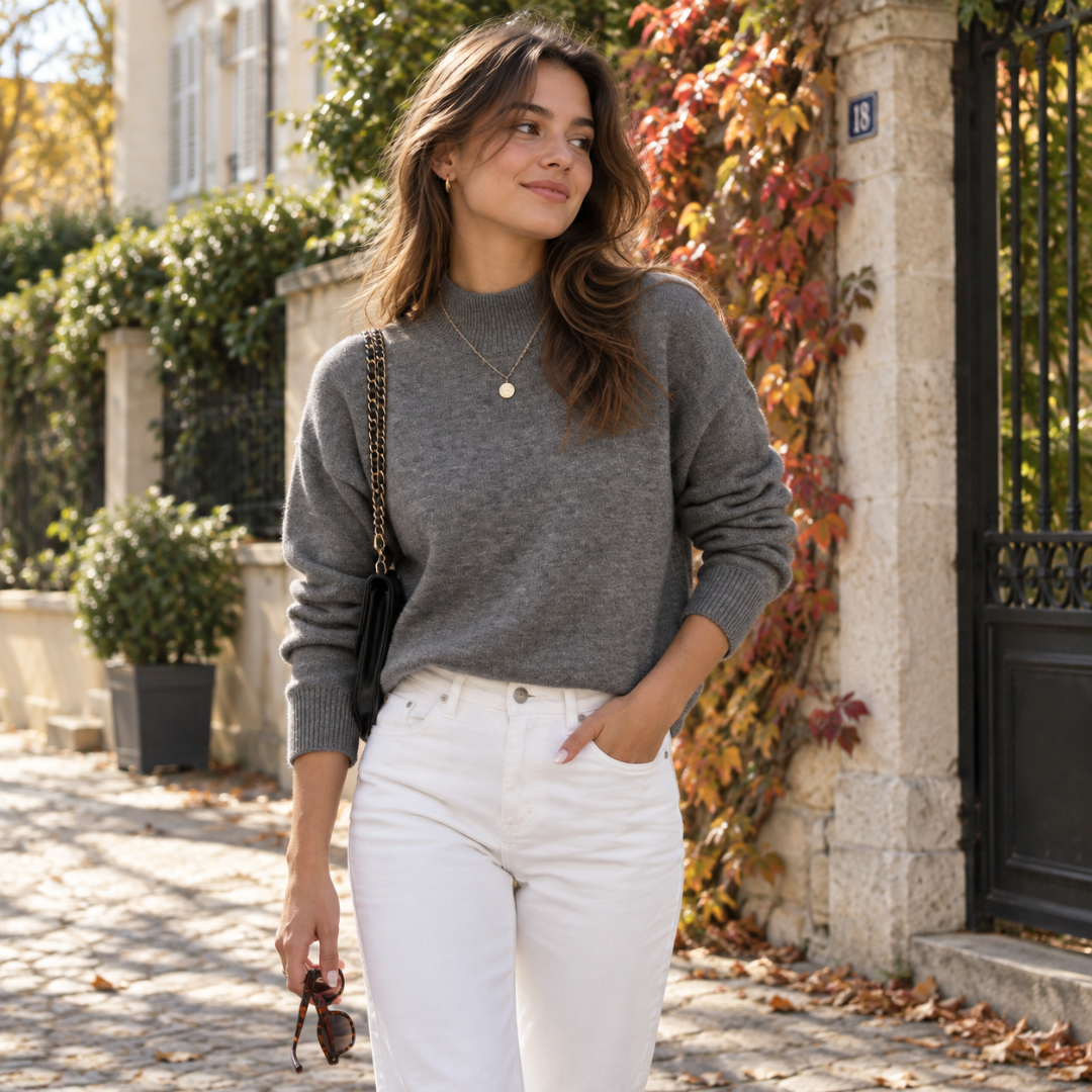 Pull femme gris à col montant, porté avec un pantalon blanc