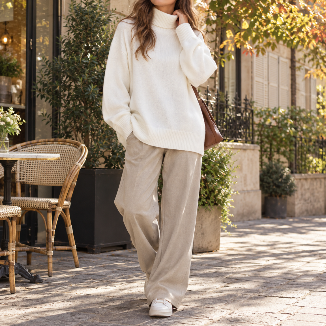 Pull femme blanc à col roulé associé à un pantalon large beige