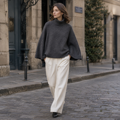 Pull femme gris foncé à col roulé, manches larges et longueur courte sur pantalon clair