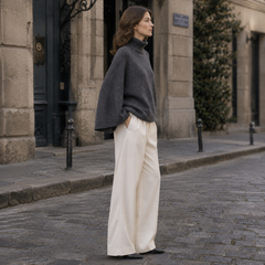 Profil du pull gris oversize, volume des manches et col roulé côtelé visible