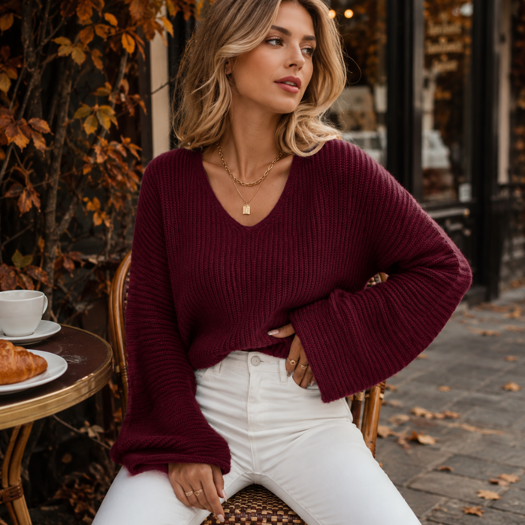 Pull bordeaux col V en maille côtelée, manches évasées, porté en terrasse de café
