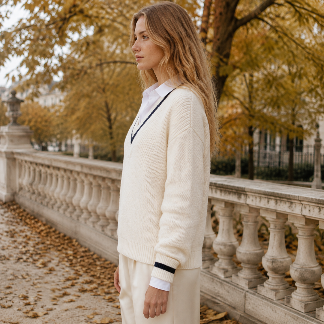 Vue de profil du pull beige, manches longues et poignets en bord-côte rayé