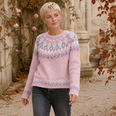 Pull femme rose porté avec un pantalon gris, bandes fleuries sur le bas