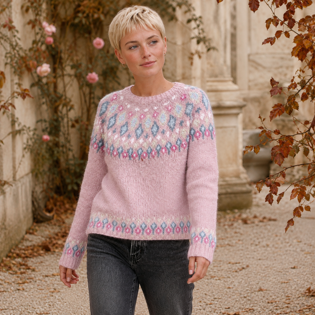 Pull femme rose porté avec un pantalon gris, bandes fleuries sur le bas