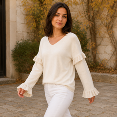 Pull femme blanc col V, poignets plissés évasés visibles sur les deux manches