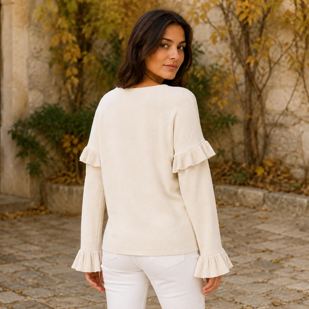 Dos du pull blanc uni avec volants plissés placés sur le haut des manches