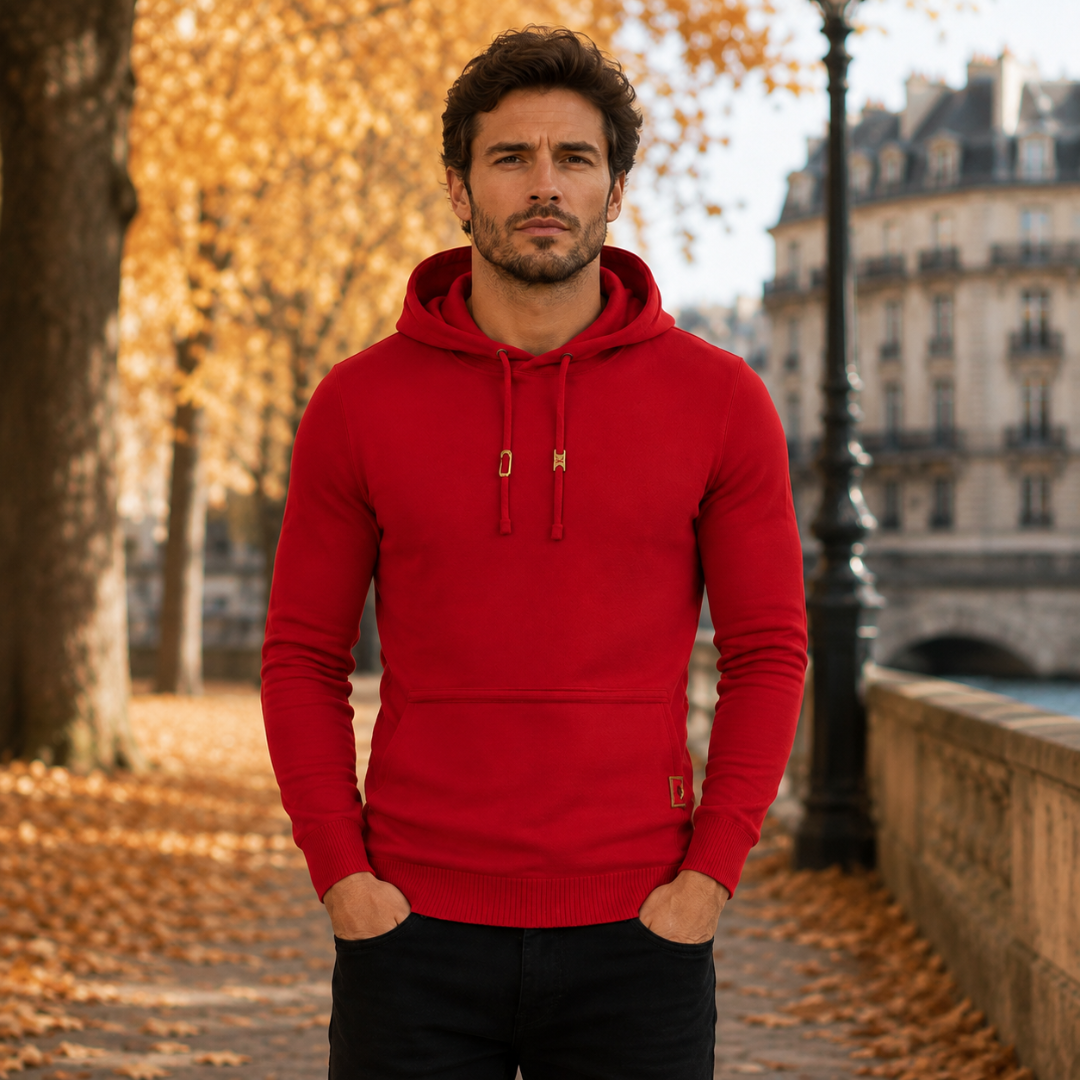 Pull homme capuche rouge vu de face, cordon à embouts dorés et bas côtelé