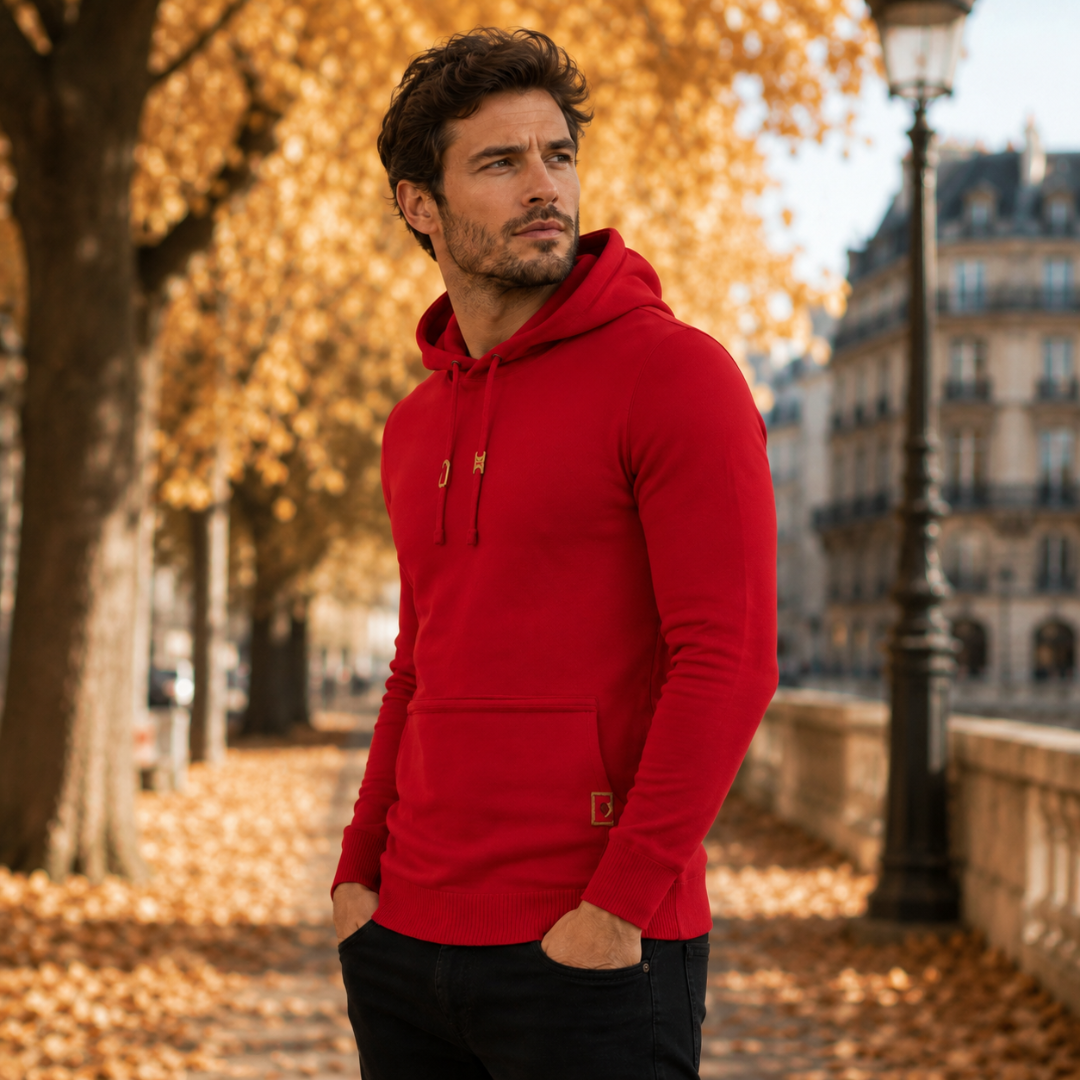 Pull homme rouge à capuche, manches longues et poignets côtelés, vue latérale en extérieur