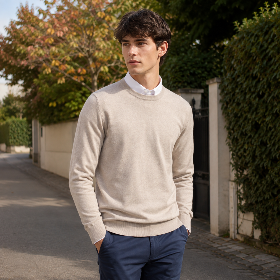 Pull homme beige à col rond, superposé sur une chemise blanche
