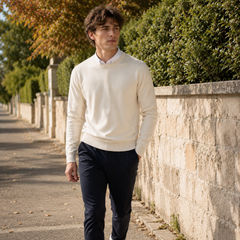 Pull crème col rond homme porté avec un pantalon bleu marine en marchant