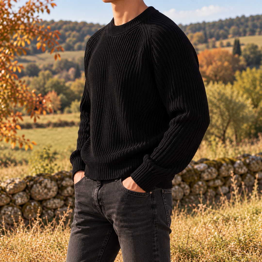 Pull homme noir côtelé porté de profil avec un pantalon foncé