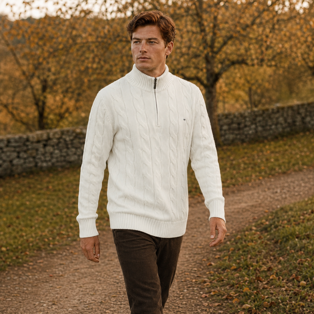 Homme en marche portant le pull blanc à maille torsadée et col zippé