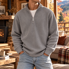 Pull homme gris à demi-zip ouvert sur le col montant, côtes verticales marquées
