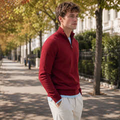 Pull homme rouge demi-zip entrouvert avec tee-shirt bleu clair et pantalon crème