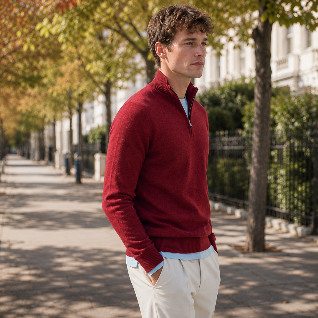 Pull homme rouge demi-zip entrouvert avec tee-shirt bleu clair et pantalon crème