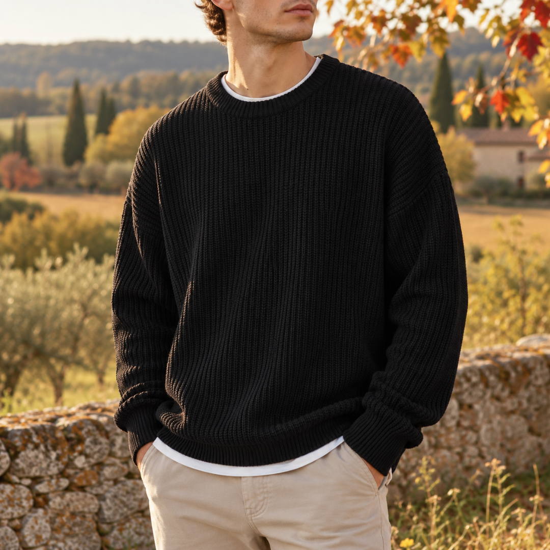 Pull homme noir en maille côtelée porté sur un t-shirt blanc et un chino