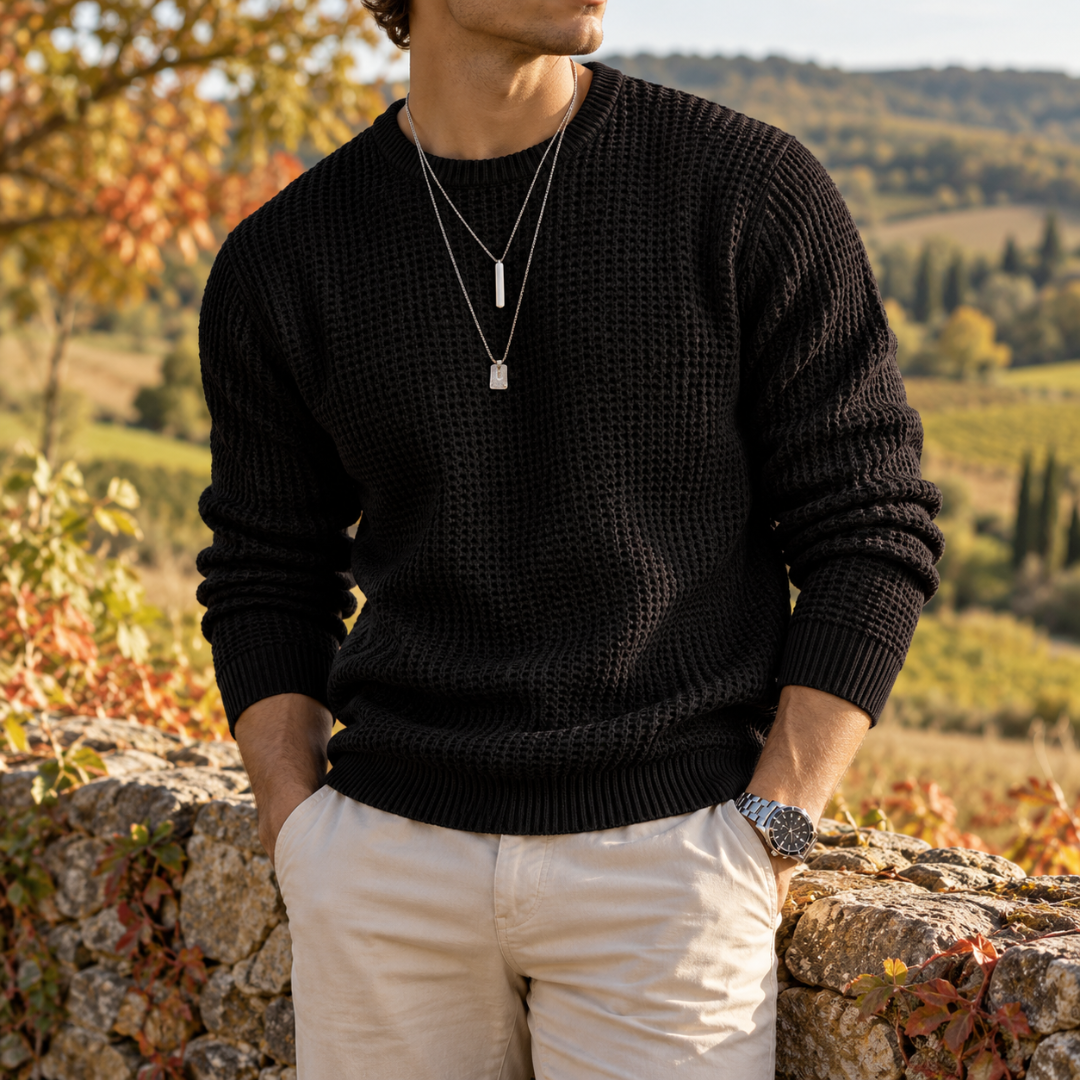 Pull homme noir en maille gaufrée, col rond, porté avec un pantalon beige
