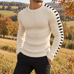 Pull blanc à col rond côtelé porté avec un pantalon noir en extérieur