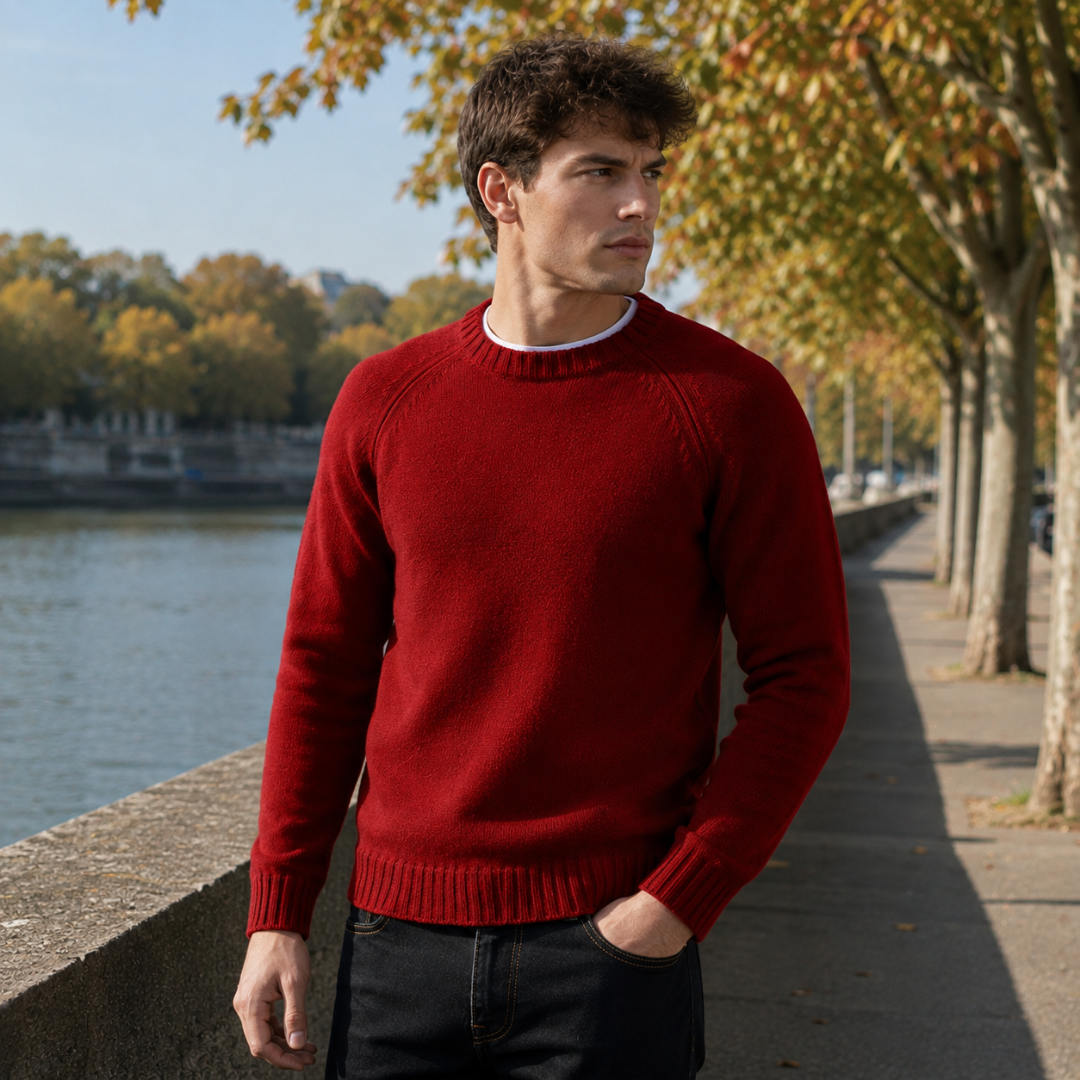 Pull homme rouge en maille unie porté sur un t-shirt blanc et un pantalon foncé