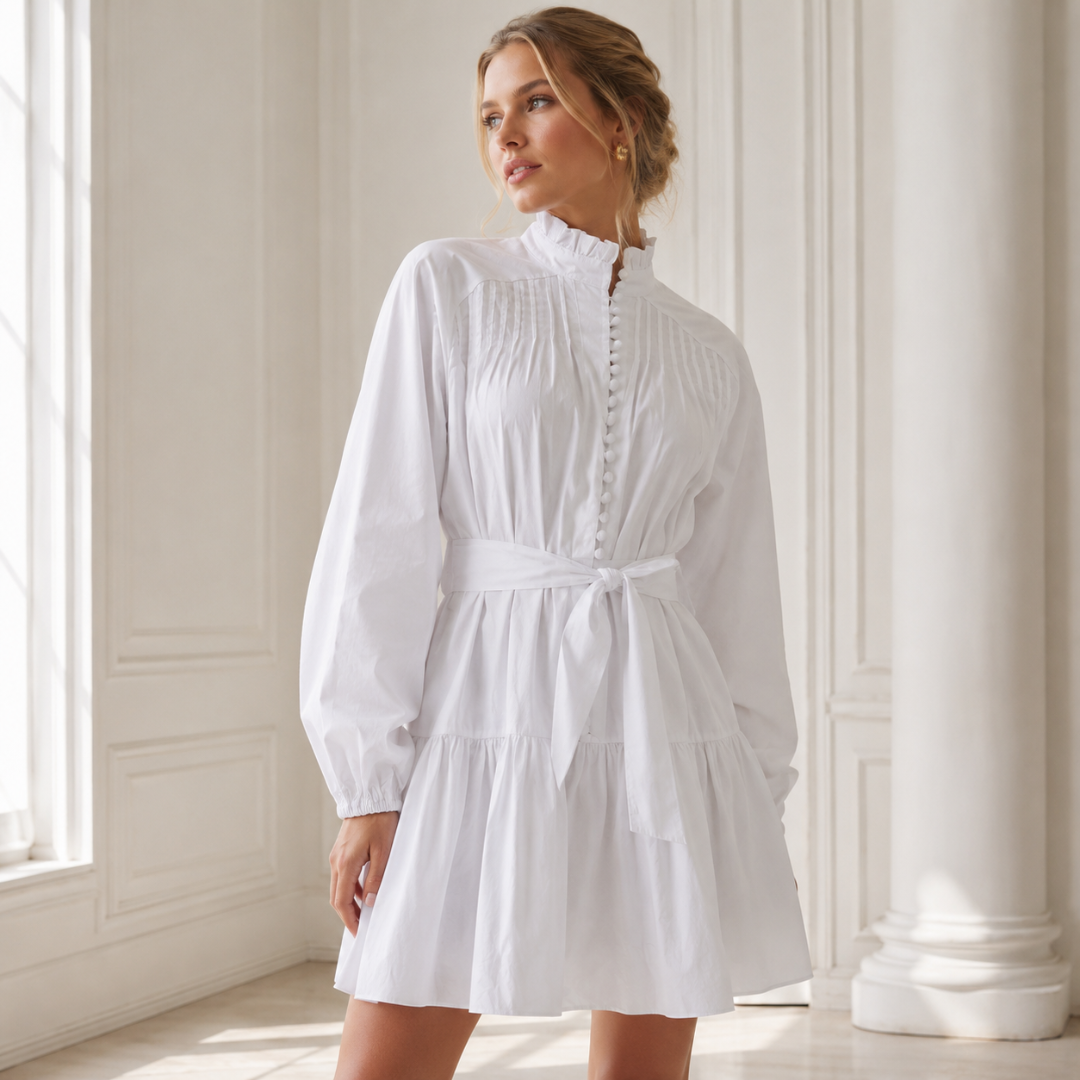 Robe courte blanche à col montant froncé et rangée de boutons, ceinture nouée devant