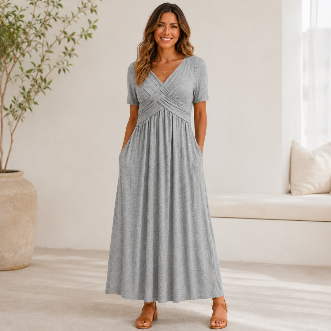 Robe longue gris clair à buste croisé, silhouette fluide en intérieur lumineux