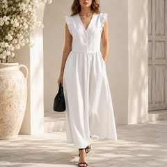 Robe longue blanche à col V, silhouette élégante sous une arche en pierre