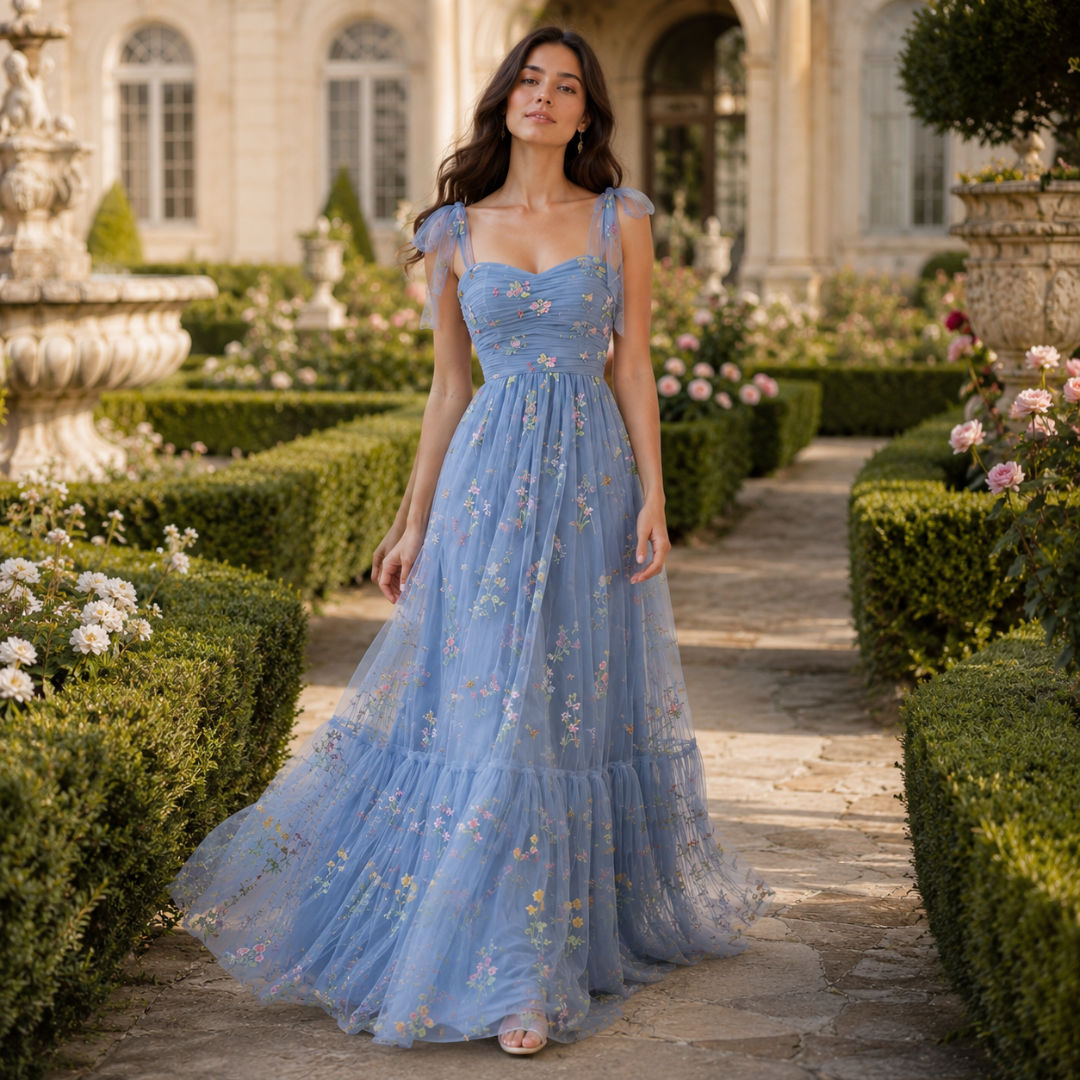 Robe longue bleue vue de trois quarts mettant en valeur la jupe évasée à broderies florales