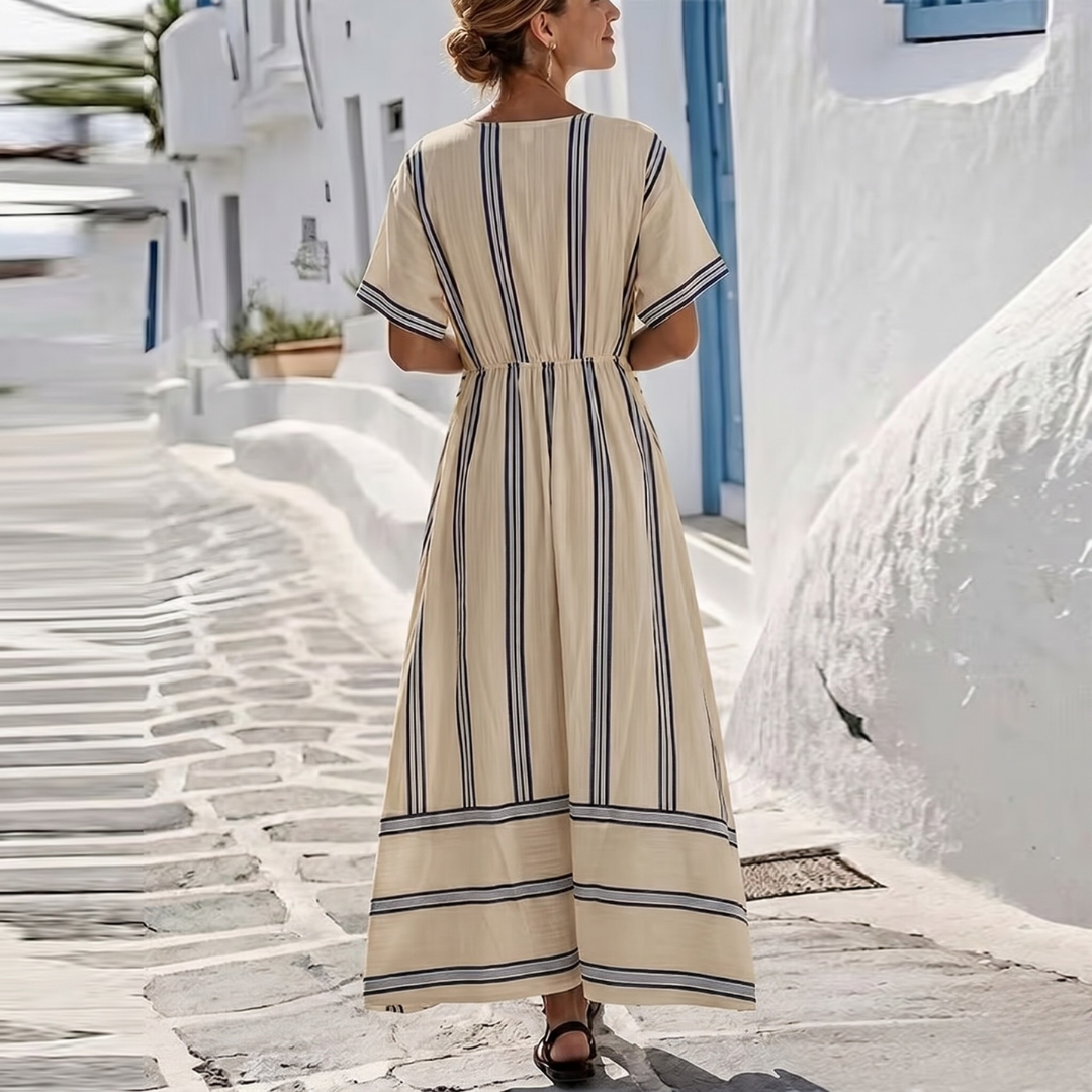 Vue de dos robe longue beige à rayures, architecture blanche en arrière-plan