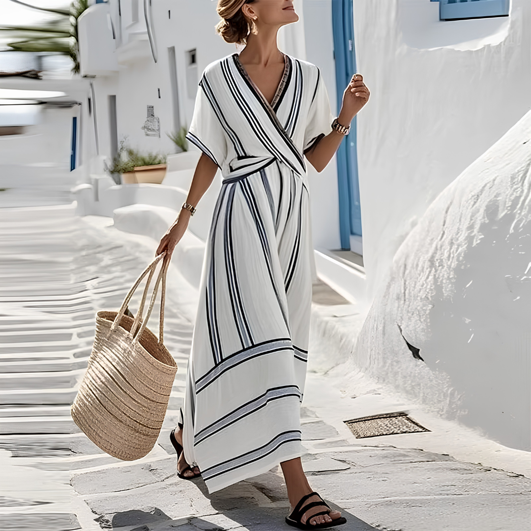 Robe maxi rayée blanc et noir col V croisé portée dans une ruelle méditerranéenne