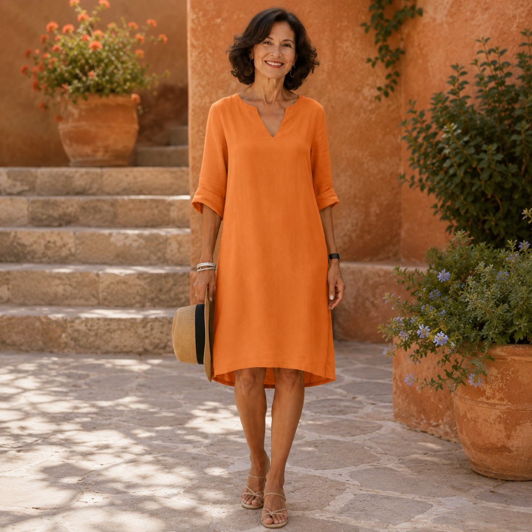 Robe femme orange vif de coupe droite avec chapeau à la main
