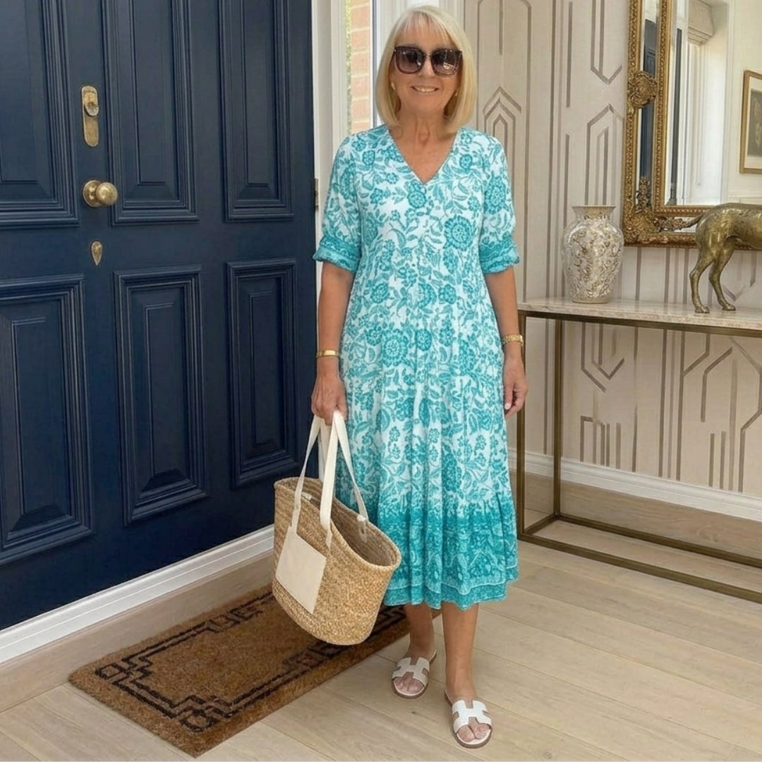 Robe midi florale turquoise et vert col V portée avec sandales blanches
