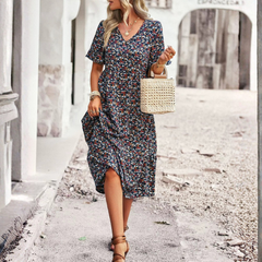 Robe midi fleurie bleue, silhouette entière de face, sac à main blanc