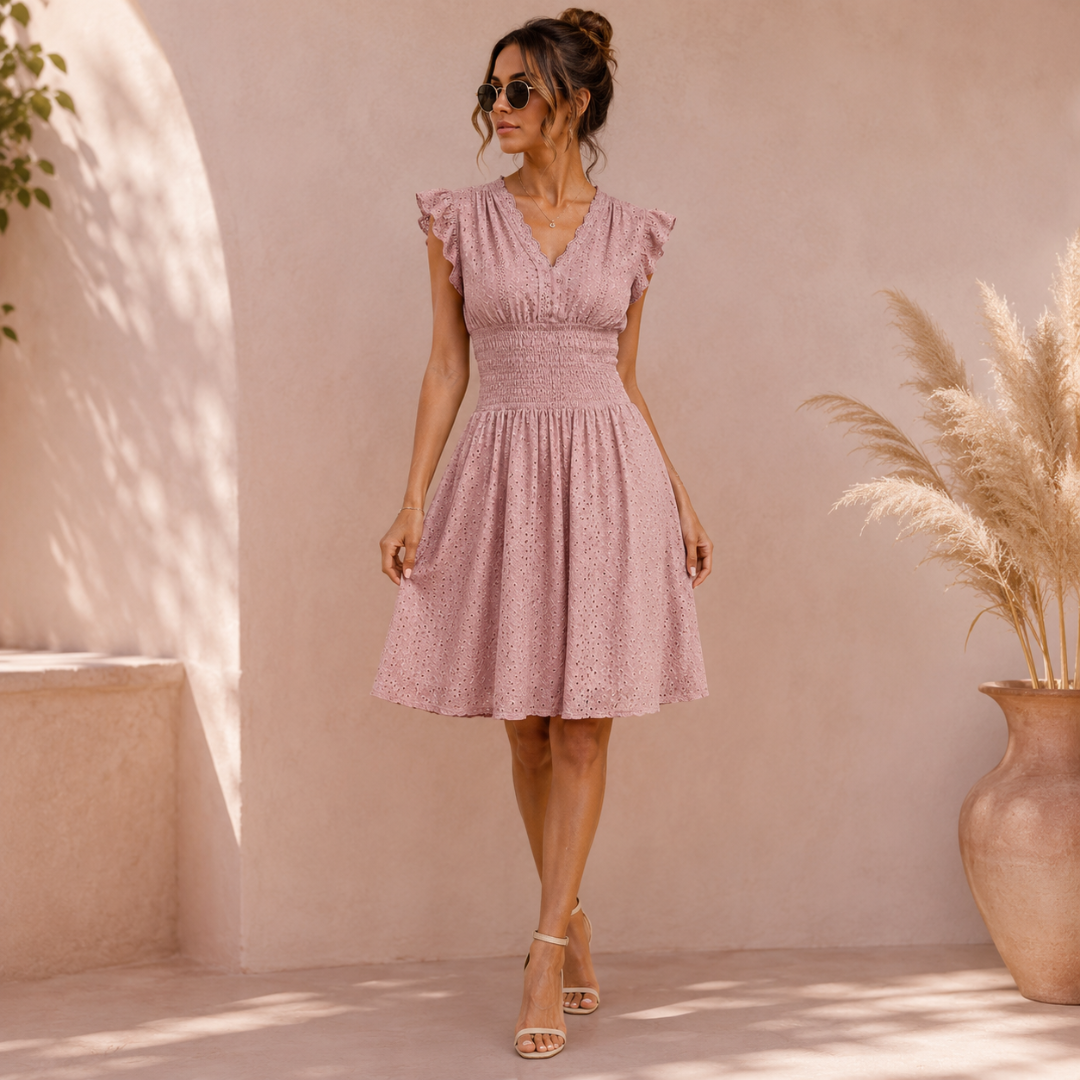 Robe rose poudré à col V et manches volantées portée en extérieur ensoleillé
