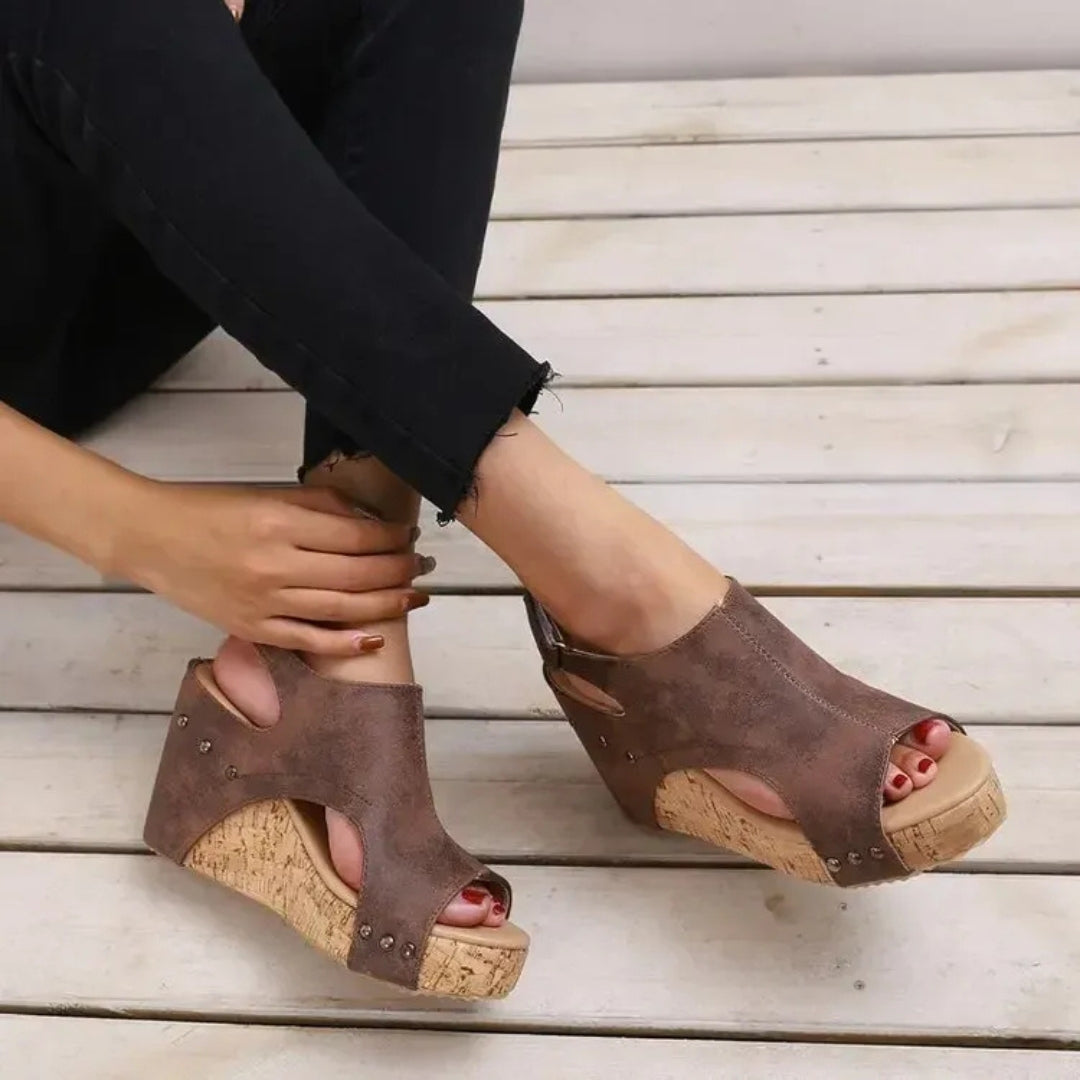 Sandales compensées brun caramel portées avec pantalon noir, vue latérale