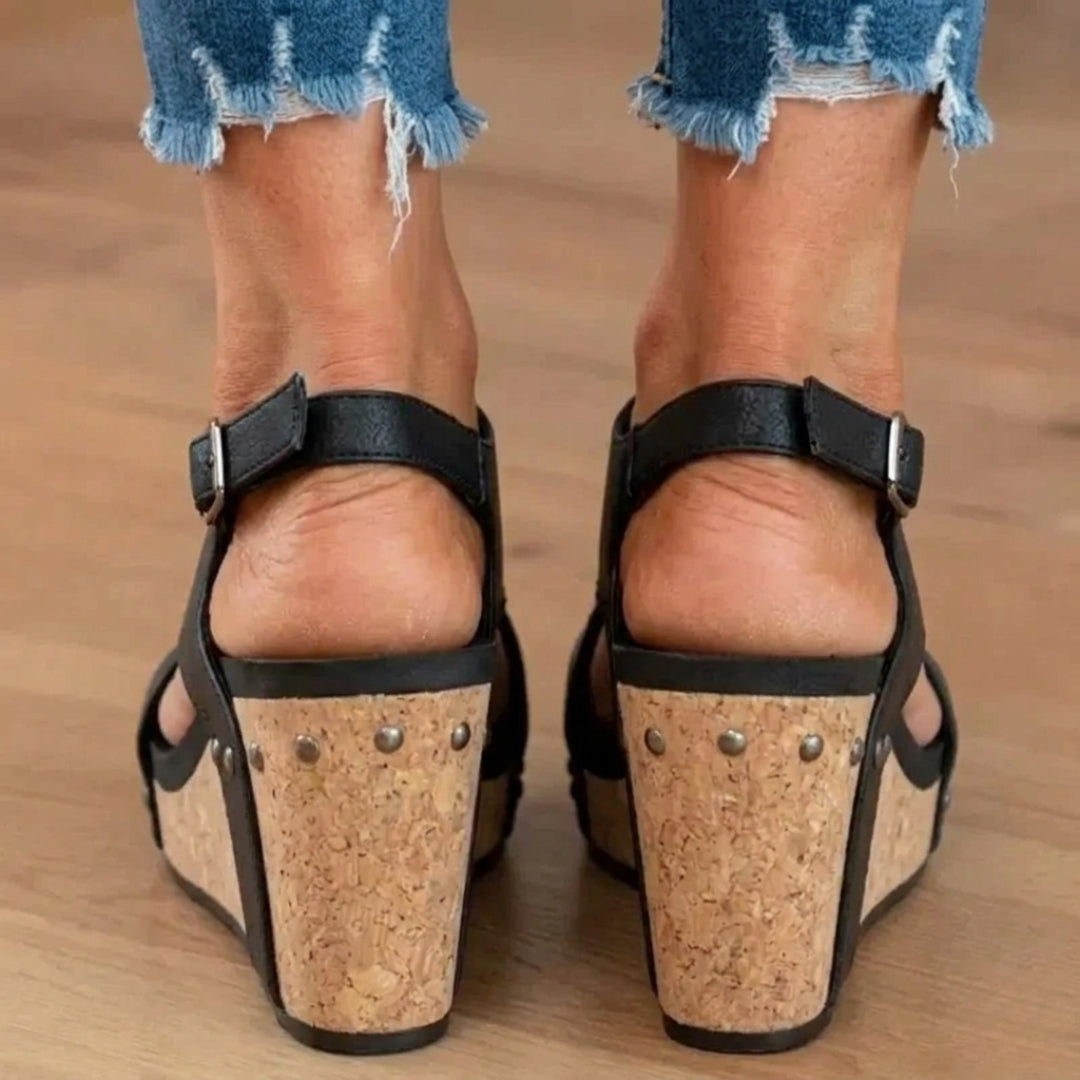 Sandales compensées noires portées, vue arrière sur talon en liège clouté