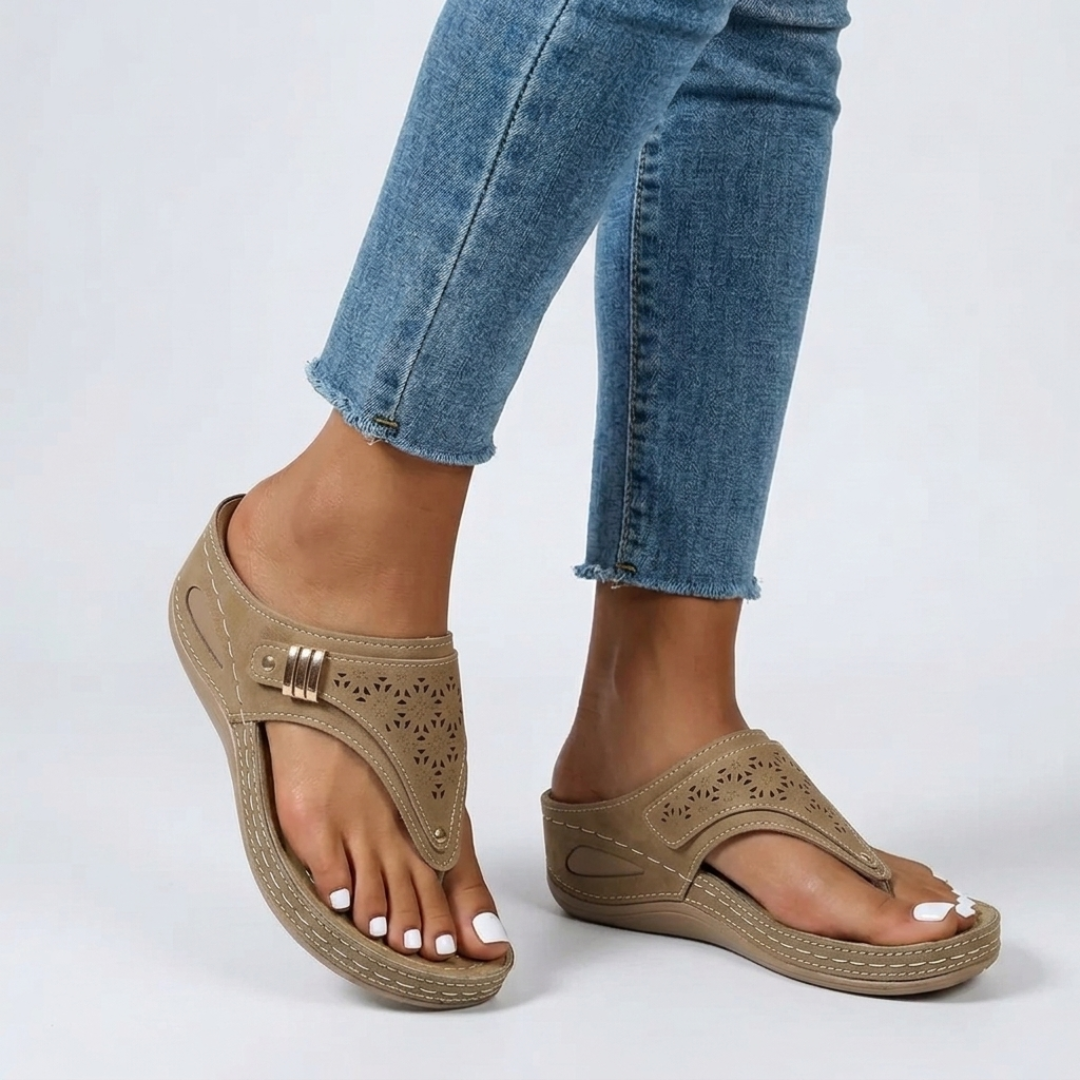 Sandales compensées beige portées avec jean effiloché, détail doré et découpes florales visibles